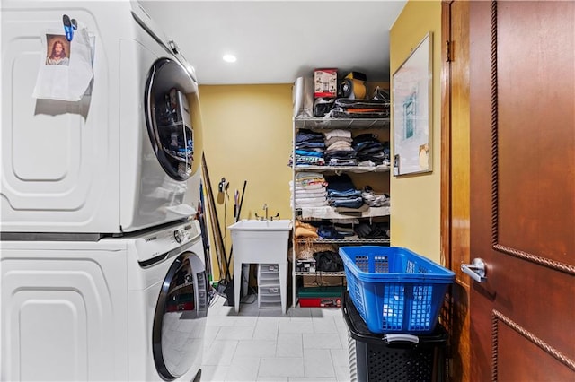 clothes washing area with sink and stacked washer and clothes dryer