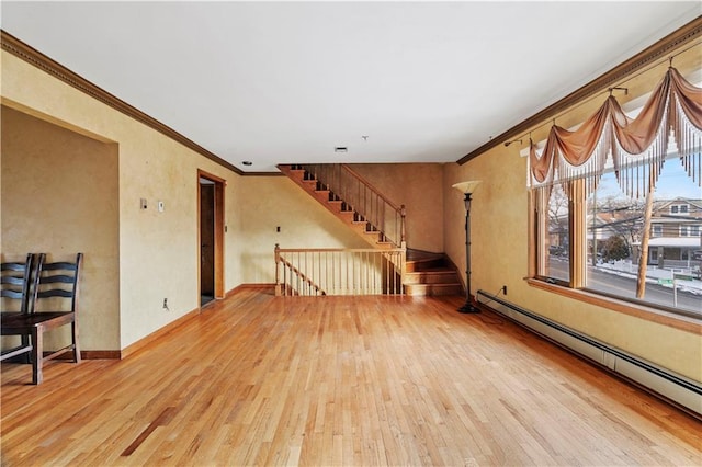 empty room with crown molding, a baseboard heating unit, and light hardwood / wood-style floors