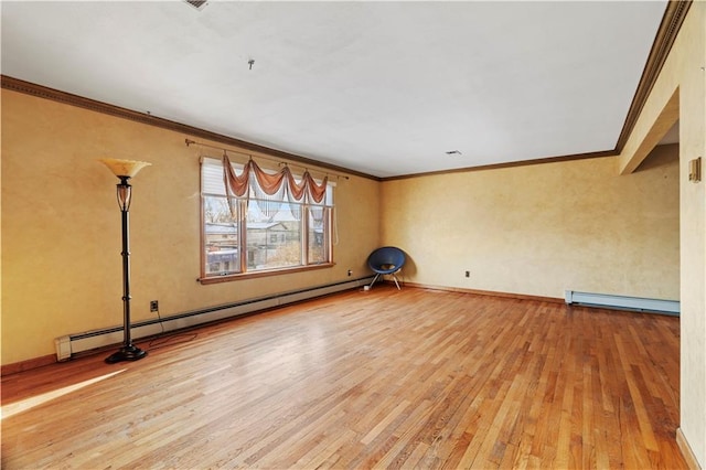 spare room featuring crown molding, hardwood / wood-style floors, and baseboard heating