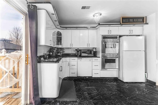 kitchen with white appliances, sink, and white cabinets