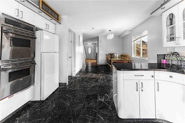 kitchen featuring white cabinetry, white fridge, double oven, and kitchen peninsula