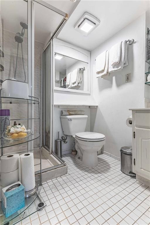 bathroom with vanity, tile patterned floors, a shower with door, and toilet