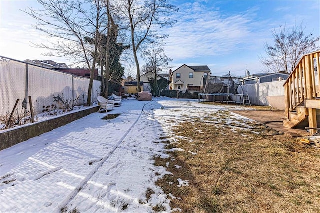 yard covered in snow with a trampoline