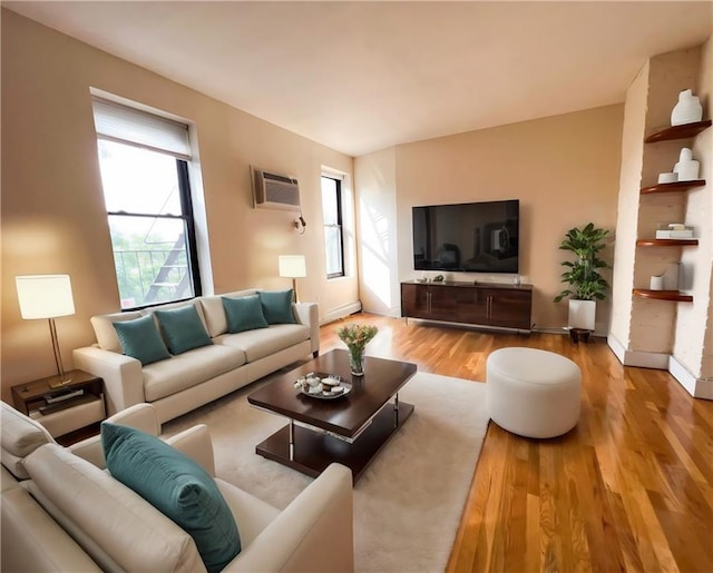 living room featuring a wall mounted air conditioner and light hardwood / wood-style flooring