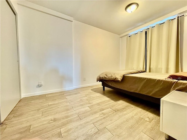 bedroom featuring baseboards and light wood-style flooring