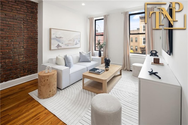 living room featuring brick wall and hardwood / wood-style floors