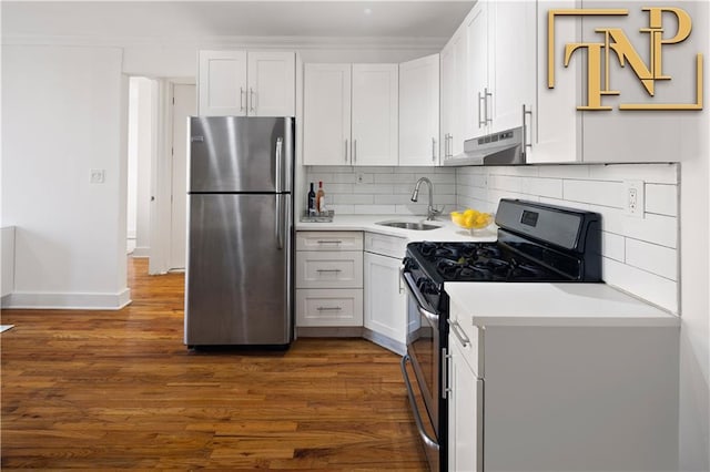 kitchen featuring dark wood-style flooring, a sink, stainless steel appliances, light countertops, and under cabinet range hood