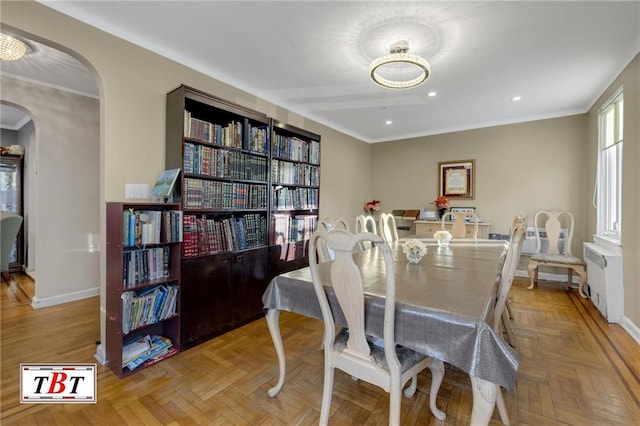 dining space with radiator heating unit, recessed lighting, crown molding, arched walkways, and baseboards