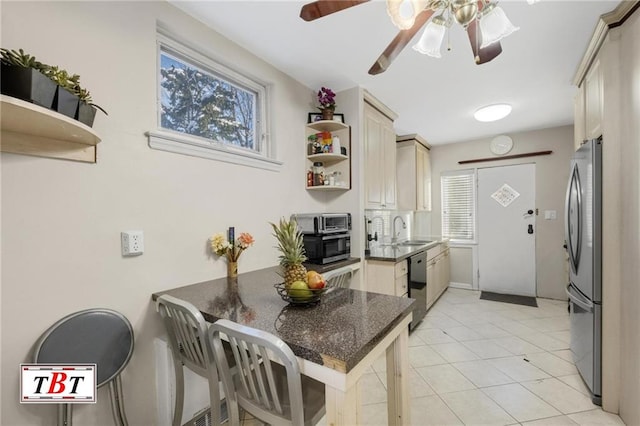 kitchen featuring dishwashing machine, a sink, open shelves, dark countertops, and freestanding refrigerator