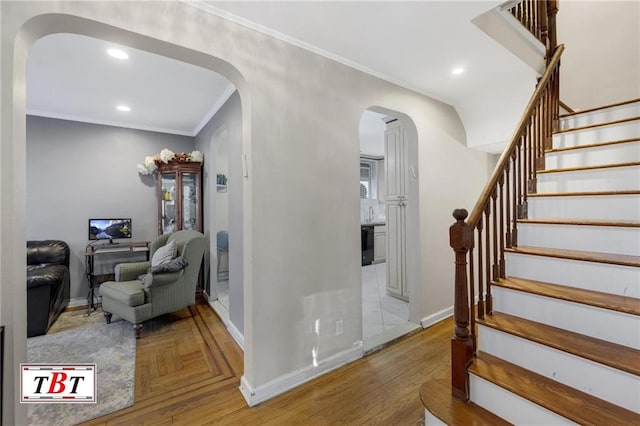 stairway with recessed lighting, baseboards, crown molding, arched walkways, and parquet floors