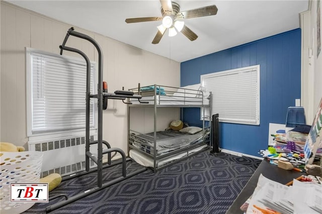 carpeted bedroom with baseboards, a ceiling fan, and radiator heating unit