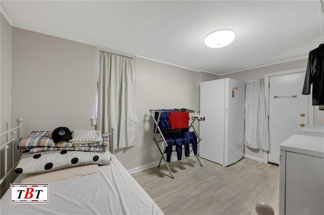 bedroom with crown molding, baseboards, freestanding refrigerator, and light wood-style floors
