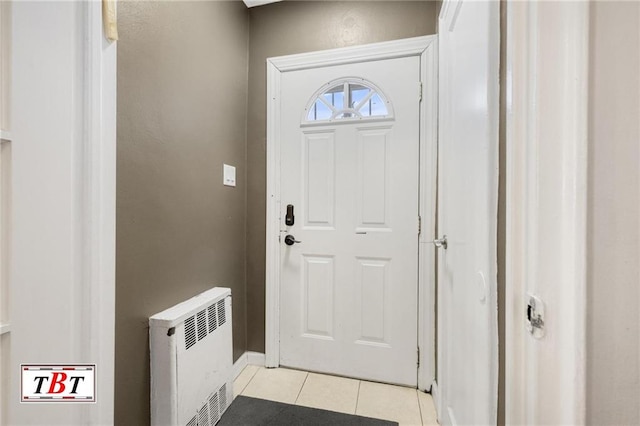 doorway to outside featuring heating unit, radiator, and light tile patterned floors