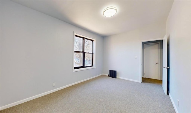 empty room with light carpet and radiator heating unit