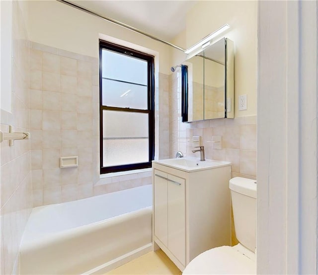 full bathroom with vanity, a washtub, toilet, and tile walls