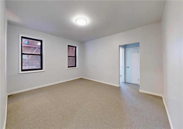 spare room featuring baseboards and carpet floors