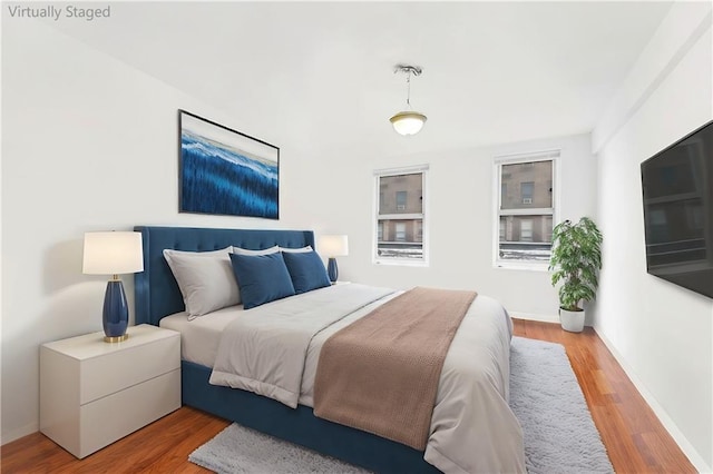 bedroom with wood finished floors and baseboards