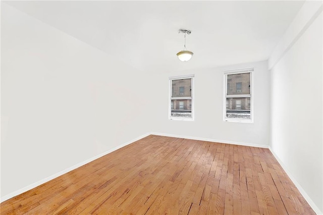 unfurnished room featuring light wood-type flooring and baseboards