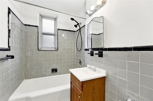 bathroom with vanity, bathtub / shower combination, and tile walls