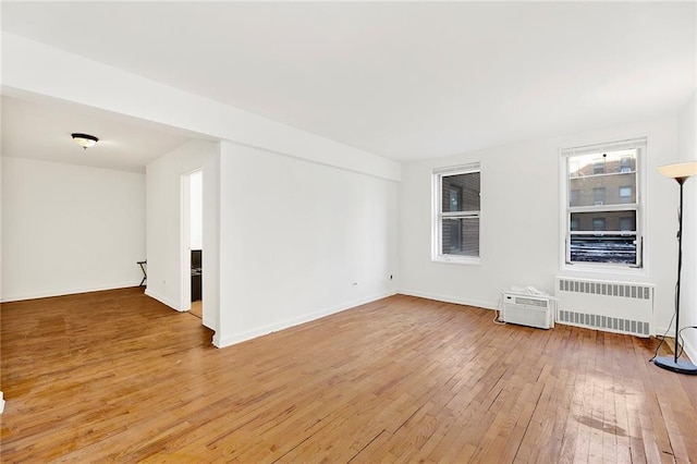 unfurnished room featuring radiator heating unit and wood-type flooring