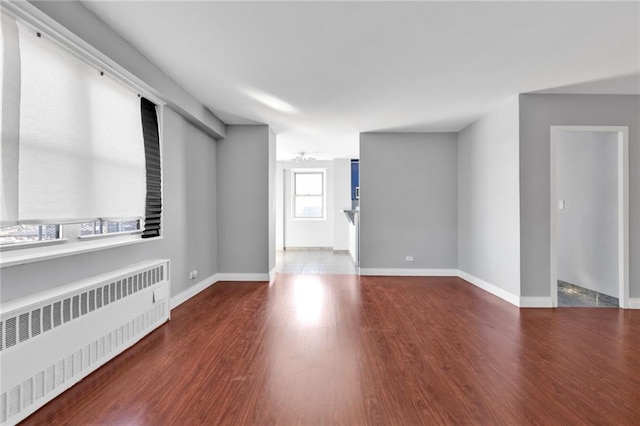 spare room featuring radiator and hardwood / wood-style flooring