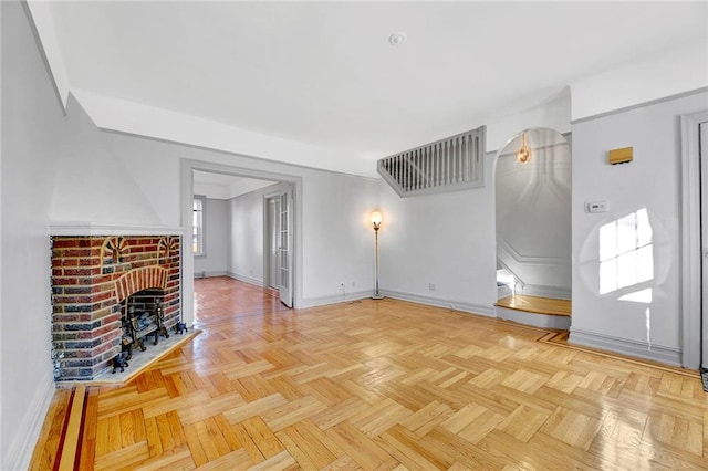 unfurnished living room featuring light parquet flooring and a fireplace