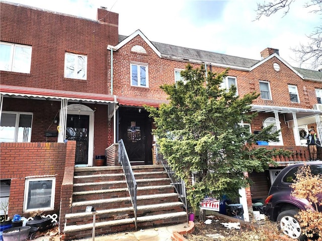 view of property with brick siding and a porch