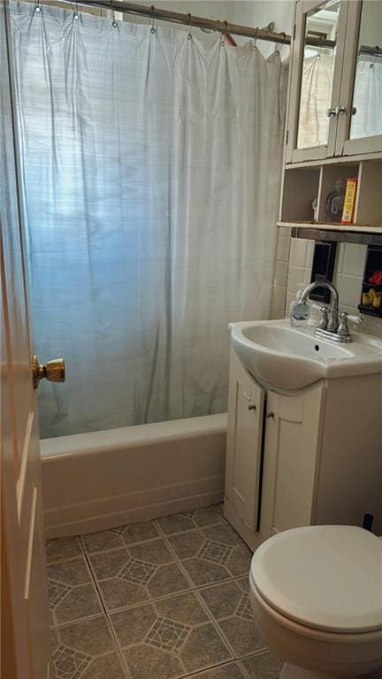 full bathroom featuring tile patterned floors, toilet, vanity, shower / bath combination with curtain, and decorative backsplash