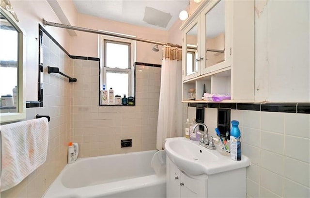 bathroom featuring tile walls, vanity, backsplash, and shower / tub combo with curtain