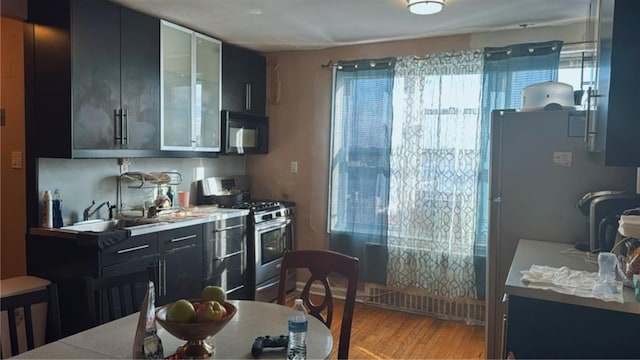 kitchen featuring gas range, sink, and light hardwood / wood-style floors