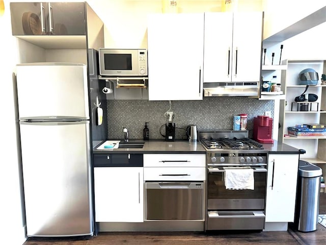 kitchen with stainless steel appliances, sink, white cabinets, and decorative backsplash