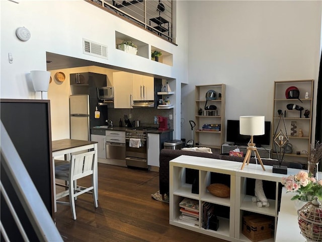 kitchen featuring appliances with stainless steel finishes, sink, dark hardwood / wood-style floors, and decorative backsplash