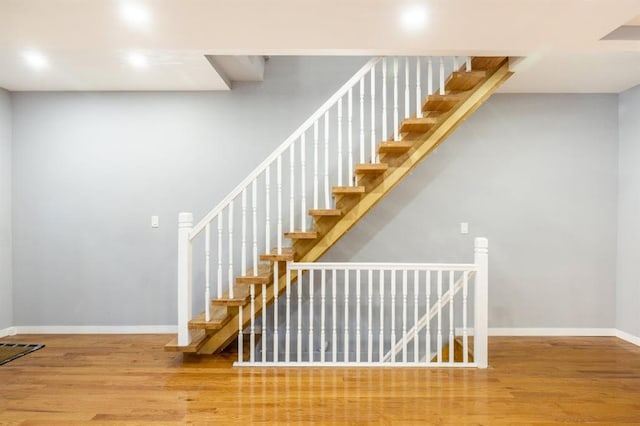 stairs featuring hardwood / wood-style floors