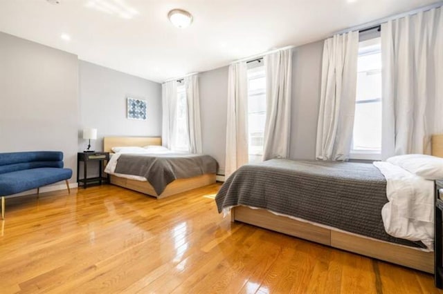 bedroom with hardwood / wood-style floors and a baseboard radiator