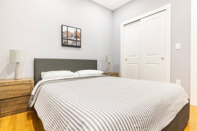 bedroom with light hardwood / wood-style flooring and a closet