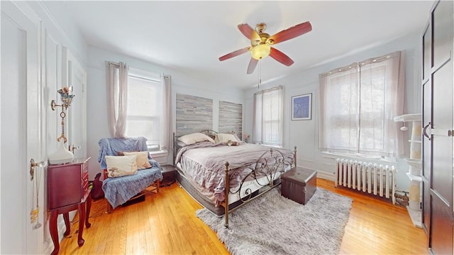 bedroom featuring radiator, hardwood / wood-style flooring, and ceiling fan