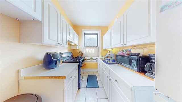 kitchen featuring white cabinetry, black gas range oven, and light tile patterned floors