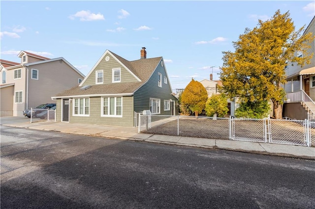 view of front of house with a fenced front yard, a gate, a chimney, and roof with shingles