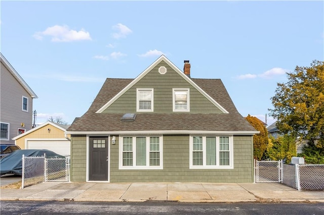 view of front of house featuring a chimney, a shingled roof, a gate, fence, and a garage