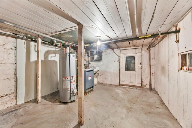 unfinished basement with a sink and water heater