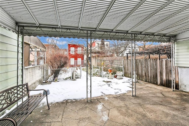 snow covered patio featuring fence