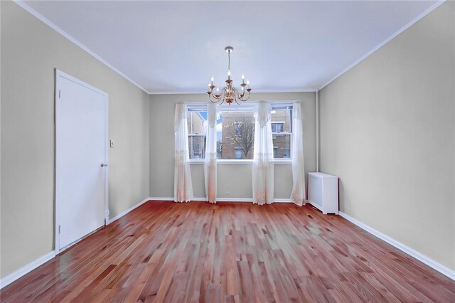 unfurnished dining area featuring radiator heating unit, ornamental molding, a chandelier, and light wood-type flooring