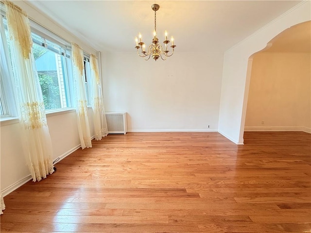 552 17th St, Brooklyn, NY 11215 - empty room with a chandelier, arched walkways, light wood-style floors, and baseboards