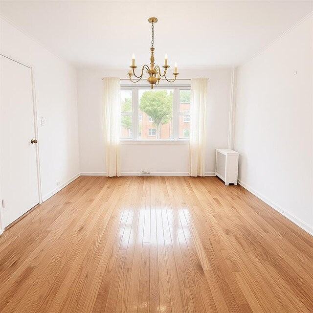 552 17th St, Brooklyn, NY 11215 - spare room with a chandelier, light wood-type flooring, and baseboards
