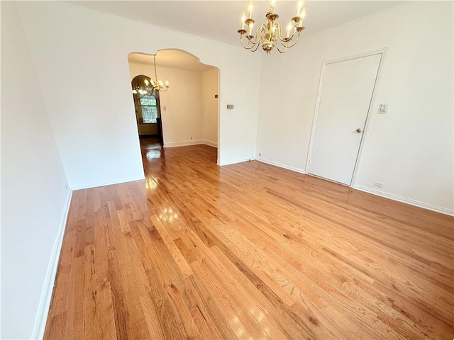 552 17th St, Brooklyn, NY 11215 - unfurnished room with arched walkways, a chandelier, light wood finished floors, crown molding, and baseboards