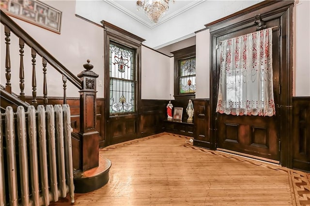 515 E 24th St, Brooklyn, NY 11210 - foyer with a wainscoted wall, ornamental molding, light wood-type flooring, stairway, and a chandelier