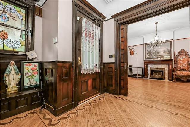 515 E 24th St, Brooklyn, NY 11210 - foyer entrance featuring a chandelier, hardwood / wood-style flooring, a wainscoted wall, and ornamental molding