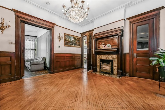 515 E 24th St, Brooklyn, NY 11210 - unfurnished living room featuring a fireplace with flush hearth, a wainscoted wall, hardwood / wood-style floors, crown molding, and a chandelier