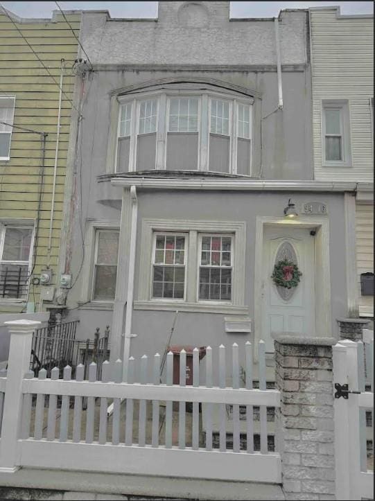 view of front of house with fence and stucco siding