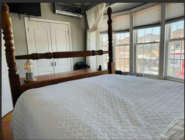 bedroom featuring multiple windows and a wall unit AC